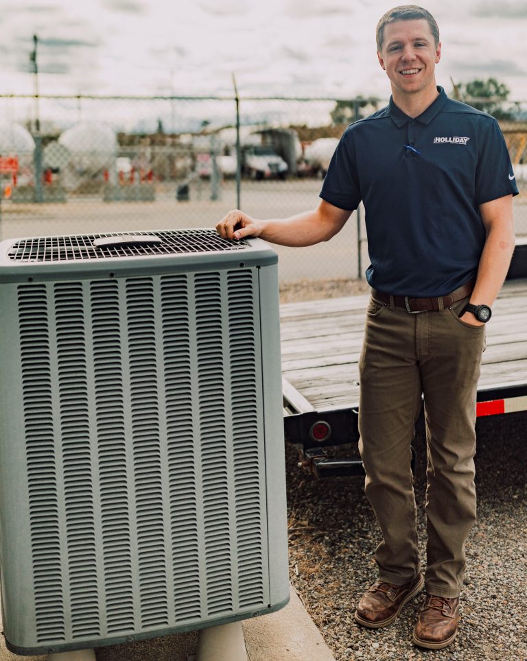 Holliday Heating HVAC technician with an air conditioning unit in Coeur d'Alene, ID